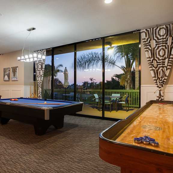 a pool table in a room with a view of the outside.