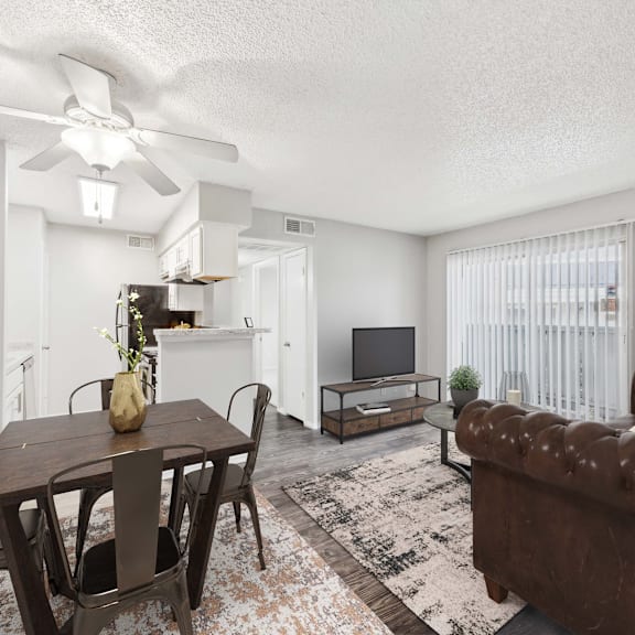 a living room with a brown couch, a wooden table, and a ceiling fan.