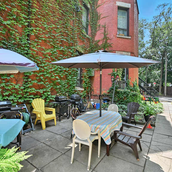 a patio with a table and chairs under umbrellas.
