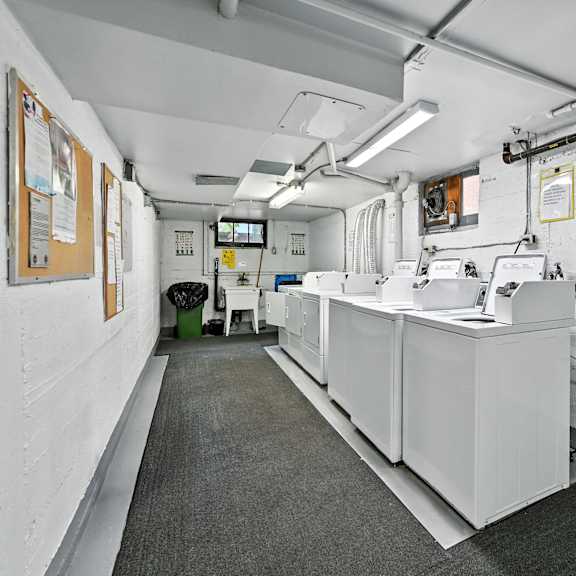a white room with a long counter and a trash can.