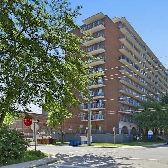 a tall apartment building with a stop sign in front of it.