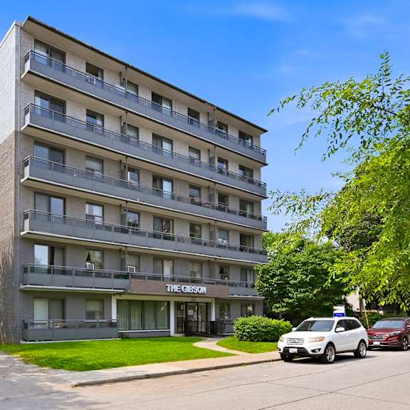 a large apartment building with a parking lot in front.