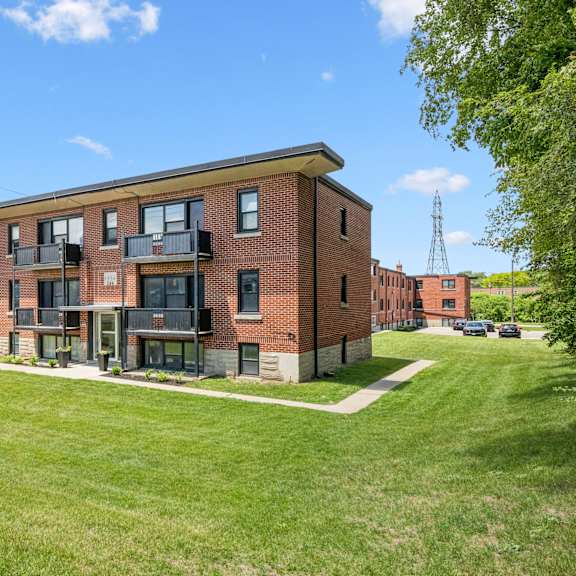 a red brick building with a green lawn in front.
