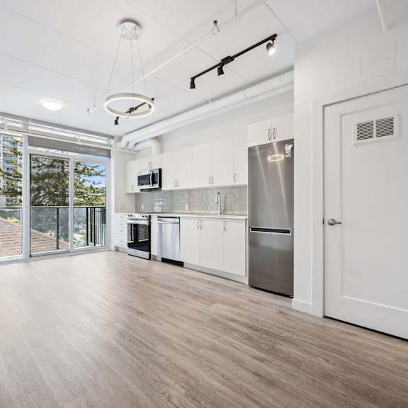 a kitchen with white cabinets and a refrigerator.