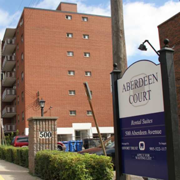 a sign for aberdeen court is in front of a brick building.