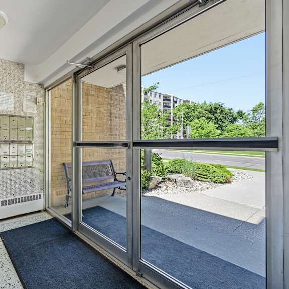 a view of a hallway with a bench and a window.