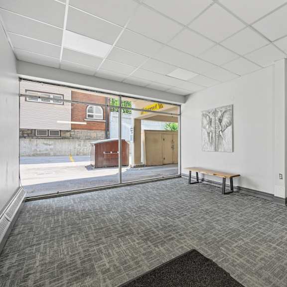 a room with a grey carpet and a white wall with a door.