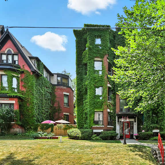 a red building with green vines growing on it.