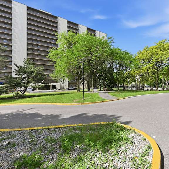 a road with a yellow line on the side and a building in the background.