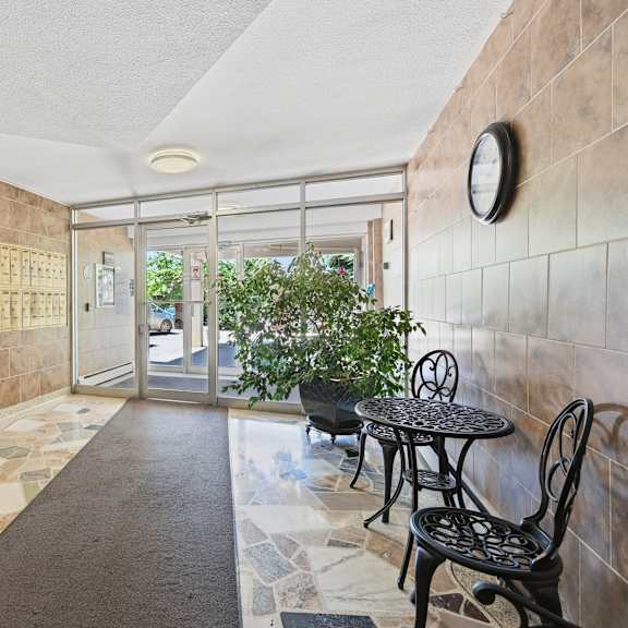 a hallway with a tiled floor and a wall of mailboxes.