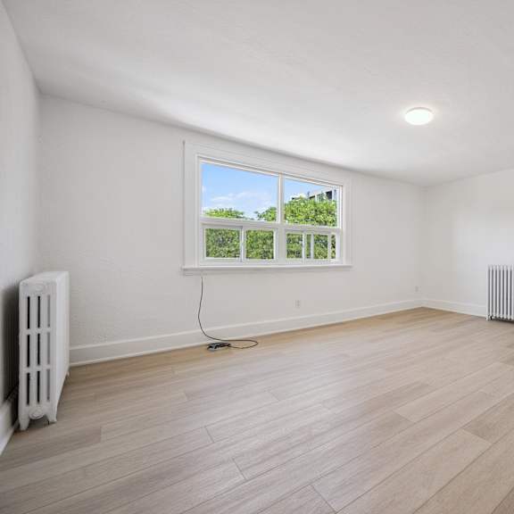 a room with a window and a radiator on the wall.