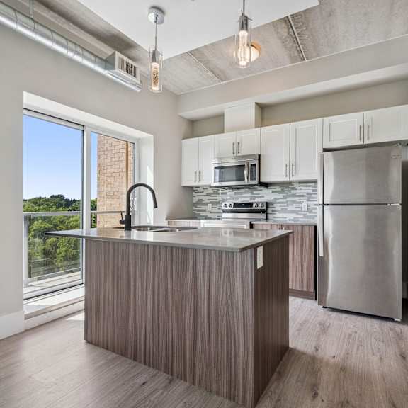 a kitchen with a large island and stainless steel appliances.