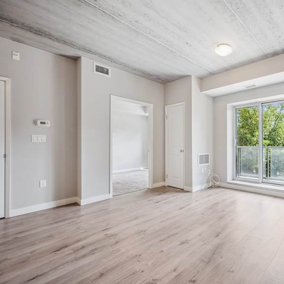 a spacious room with wooden floors and a large window.