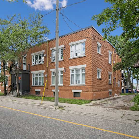 a red brick building with a black gate in front.