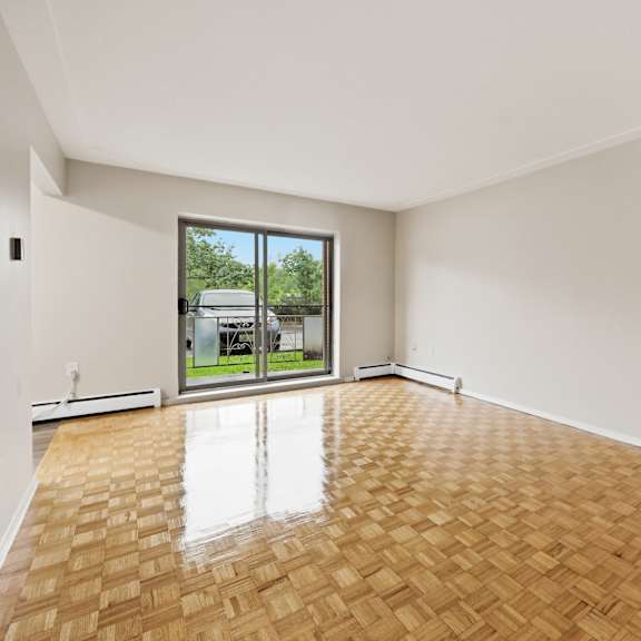 a room with wooden flooring and a large window.