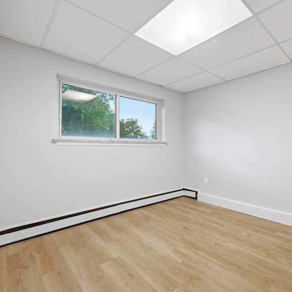 a room with a window and wooden flooring.