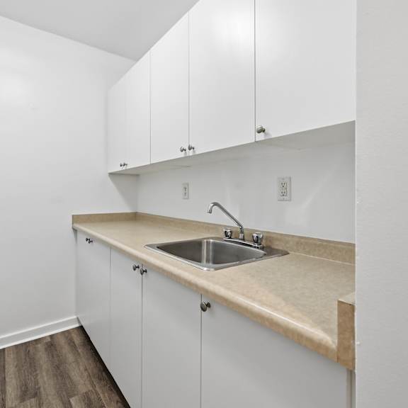 a kitchen with white cabinets and a beige countertop.