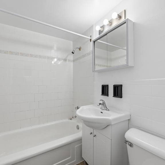 a white bathroom with a sink, toilet, and bathtub.