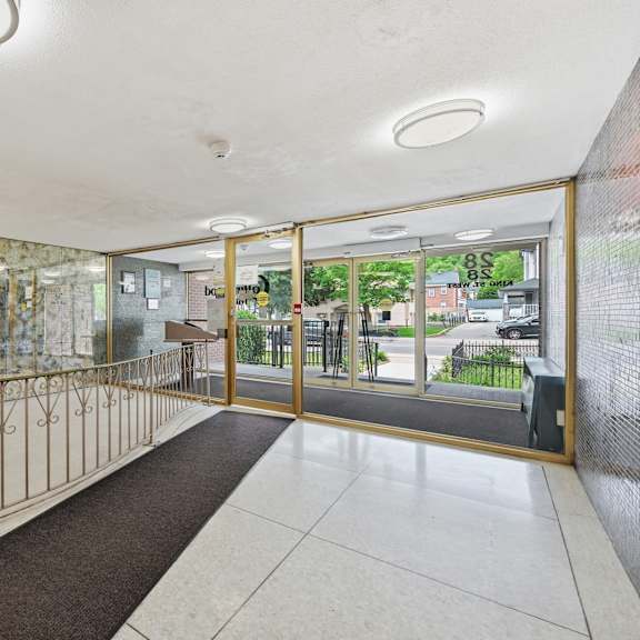 a hallway with a bench and a glass door leading outside.