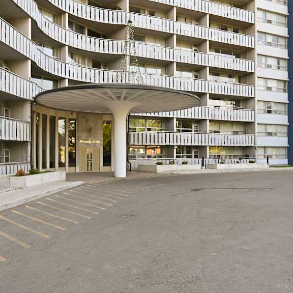 a large parking lot in front of a white building with a lot of windows.