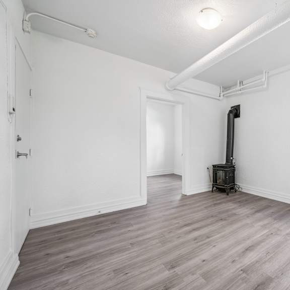 a room with a wood floor and a window showing a building outside.