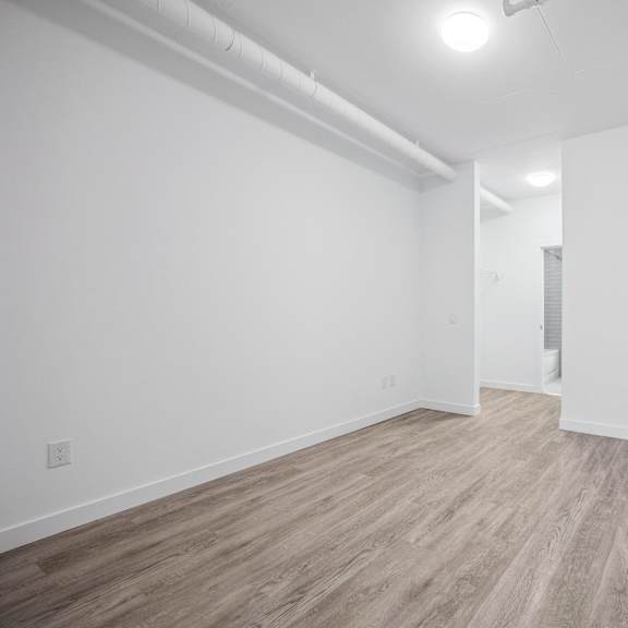 a room with wooden flooring and white walls.