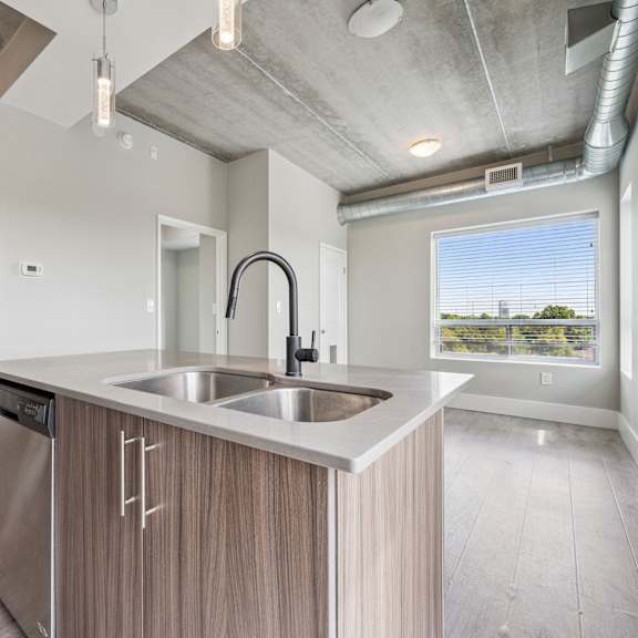 a modern kitchen with a stainless steel sink and wooden cabinets.