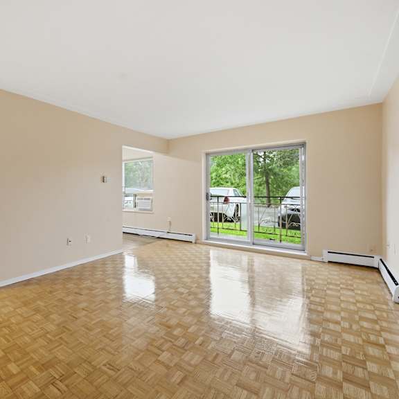 empty room with wooden flooring and white walls.