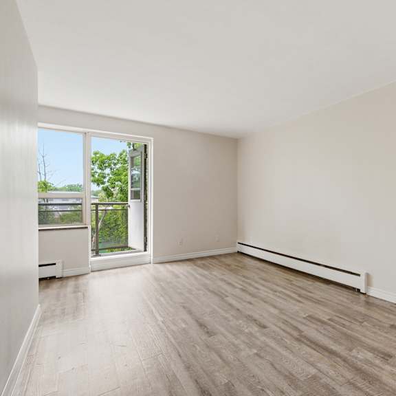 empty room with a window and a radiator on the wall.