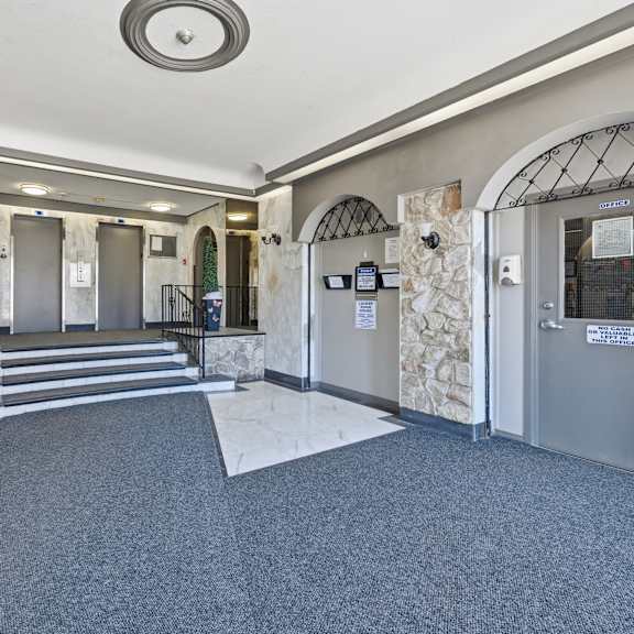 a hallway with a stone wall and metal gates.