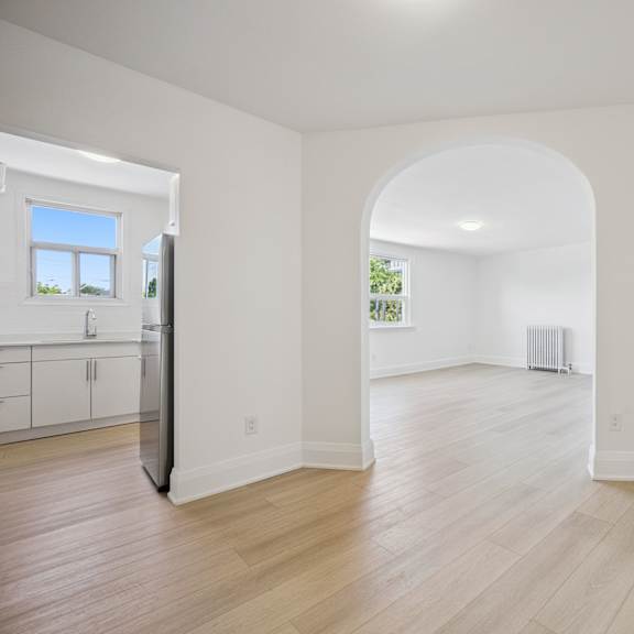a spacious room with a window and a doorway leading to another room.