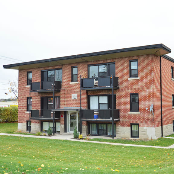 a red brick building with black balconies and windows.