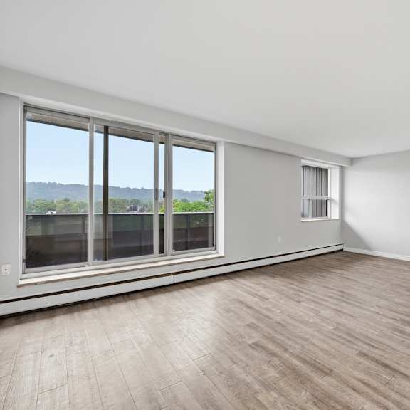 a room with a large window and wooden flooring.
