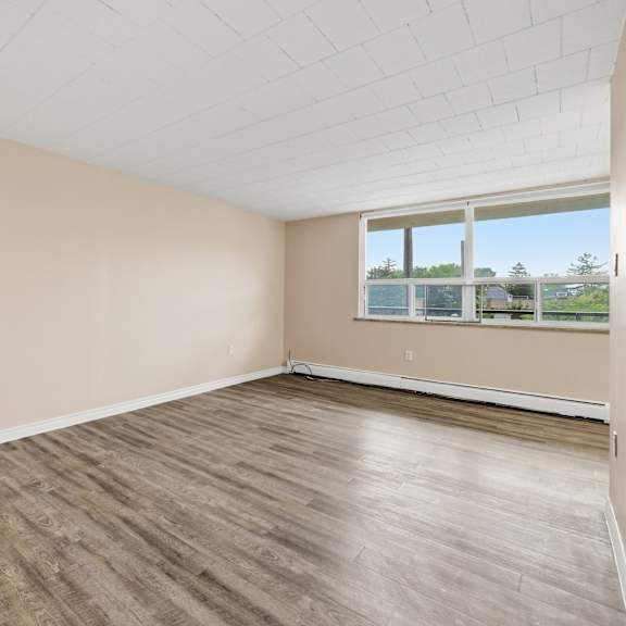 empty room with wooden flooring and a window.