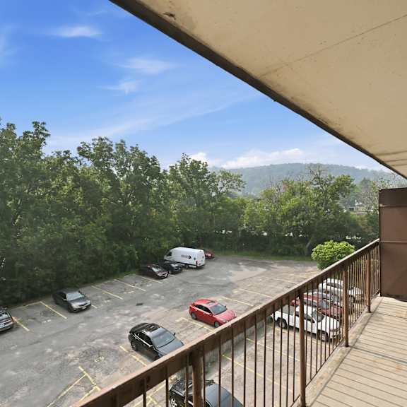 a parking lot with cars and a mountain in the background.