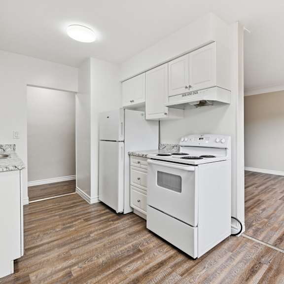 a white kitchen with a white oven and white cabinets.