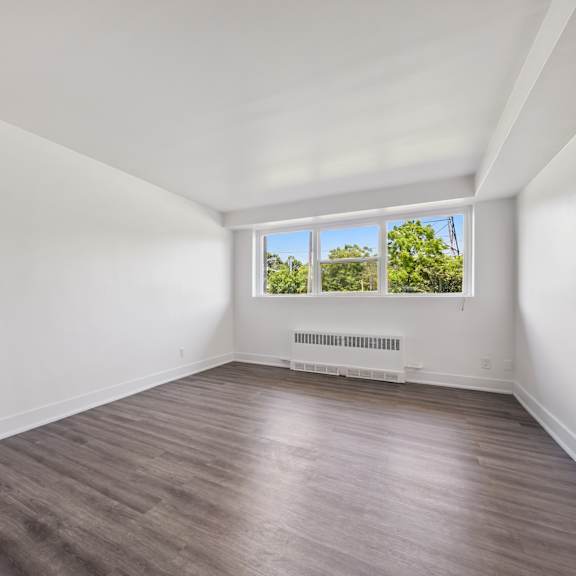a room with a window overlooking a green area.
