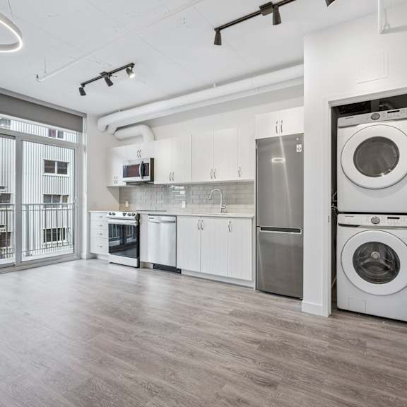 a modern kitchen with a washing machine in the doorway.