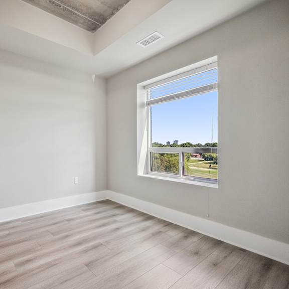 a room with a window overlooking a green area.