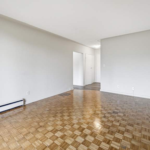 a room with a wooden floor and white walls.