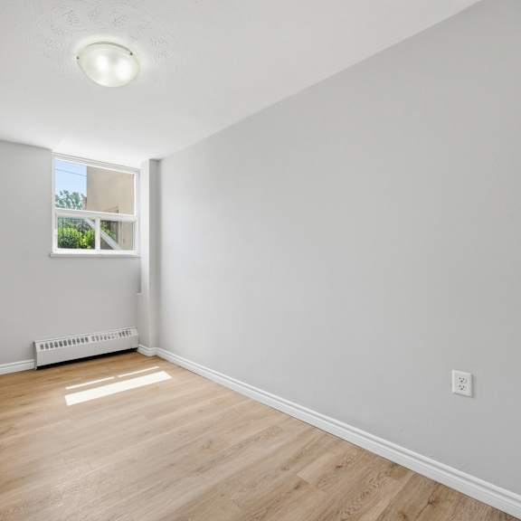 a room with a window and a wooden floor.