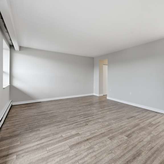 a room with wooden flooring and white walls.