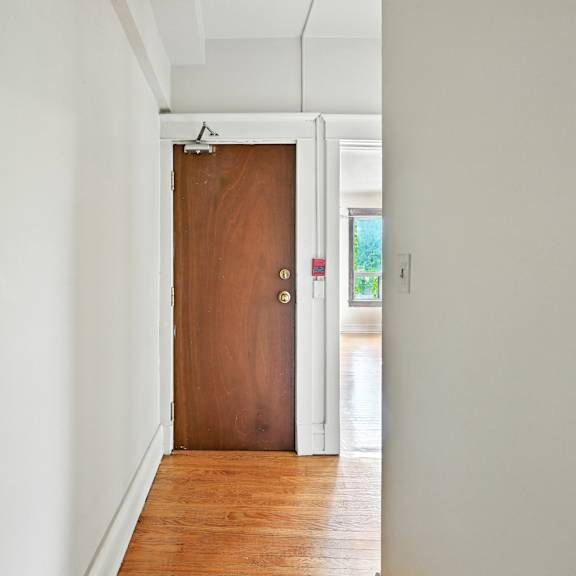 a brown door is in a white hallway.