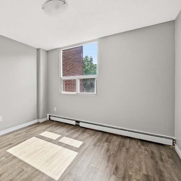 a room with a window and a wooden floor.