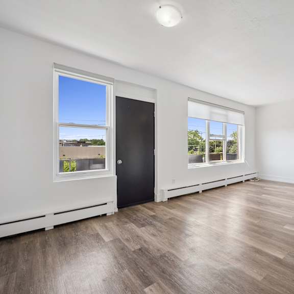 a room with a black door and a window overlooking a beach.
