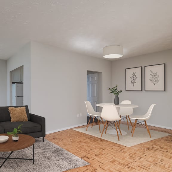 a living room with a grey couch, a brown coffee table, and a dining table with chairs.