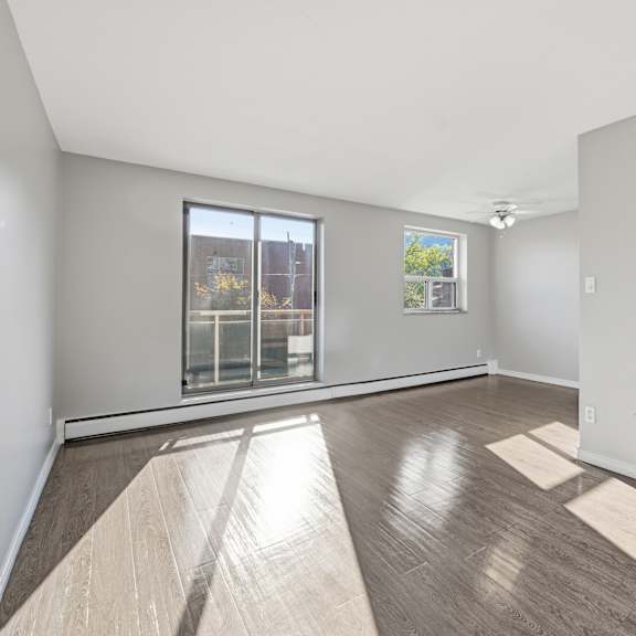 a room with wooden flooring and a large window.