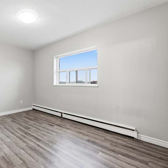 a room with a window and a wooden floor.