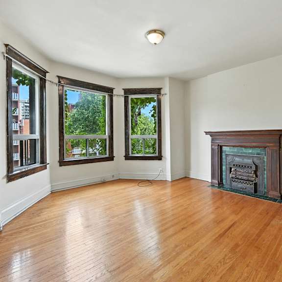 a room with a fireplace and wood flooring.