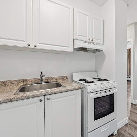 a kitchen with white cabinets and a stove top oven.